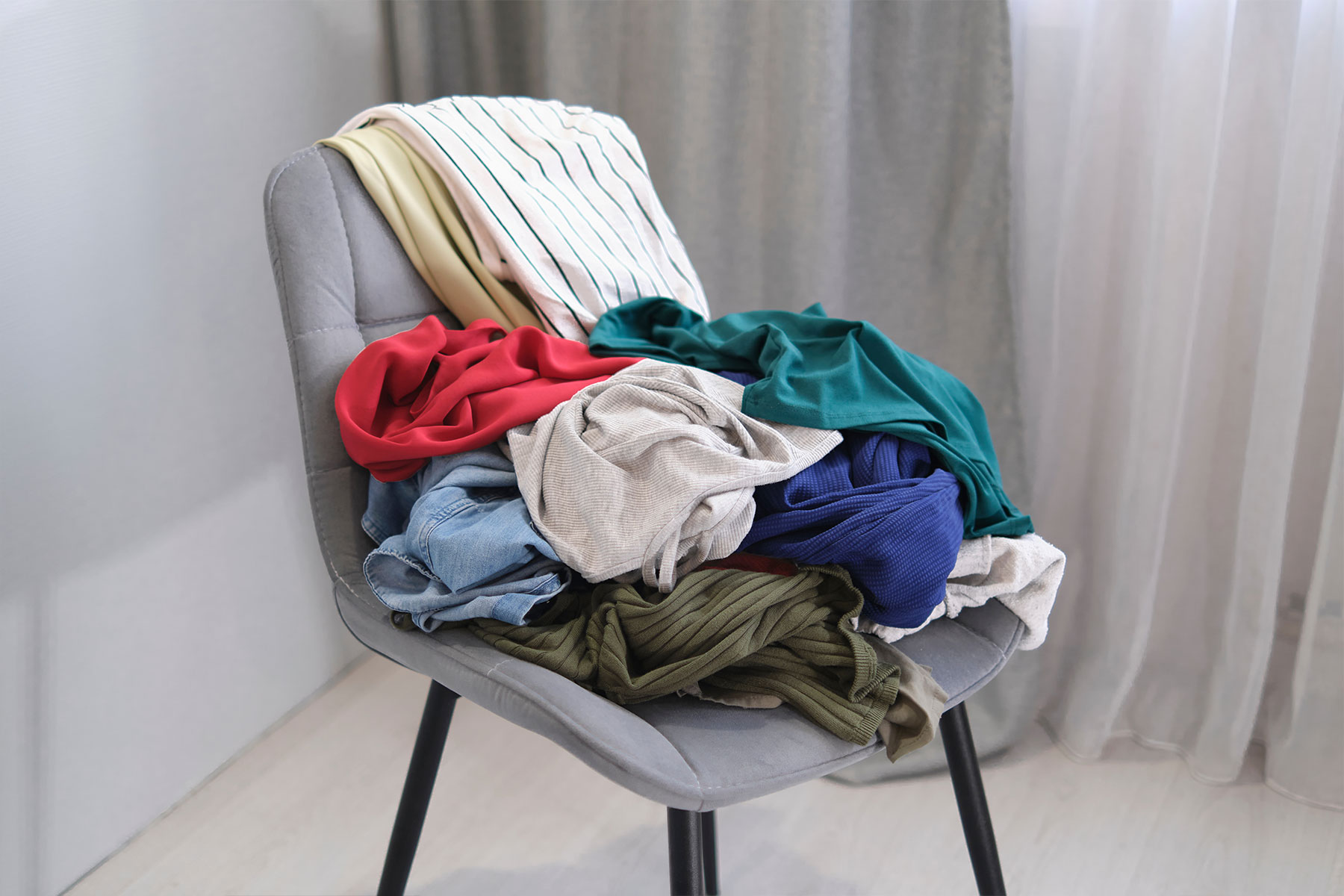 Pile of lightly worn clothes on a bedroom chair